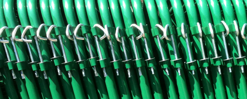 Stacks of green-painted steel farm gates manufactured at Heritage Gate Company